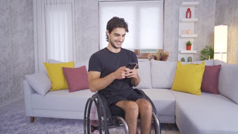 Disabled-teenager-sitting-in-a-wheelchair-texts-on-the-phone.